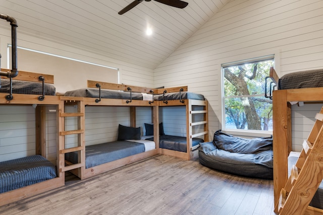 unfurnished bedroom featuring wood-type flooring, wooden walls, vaulted ceiling, and wooden ceiling