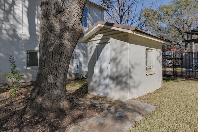 view of side of property featuring a storage unit and a lawn