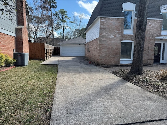 view of side of property with an outbuilding, a yard, a garage, and central air condition unit