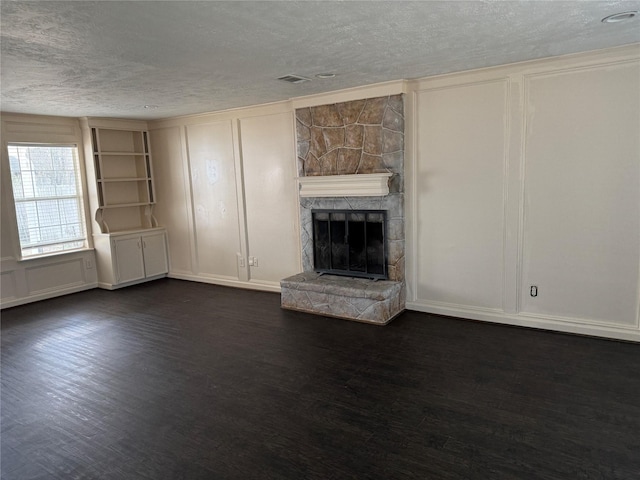 unfurnished living room with dark hardwood / wood-style floors, a fireplace, and a textured ceiling