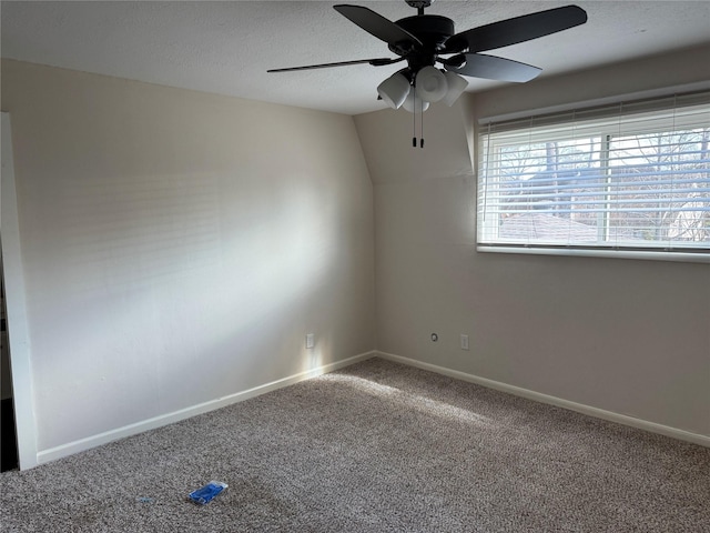 unfurnished room featuring lofted ceiling, ceiling fan, a textured ceiling, and carpet