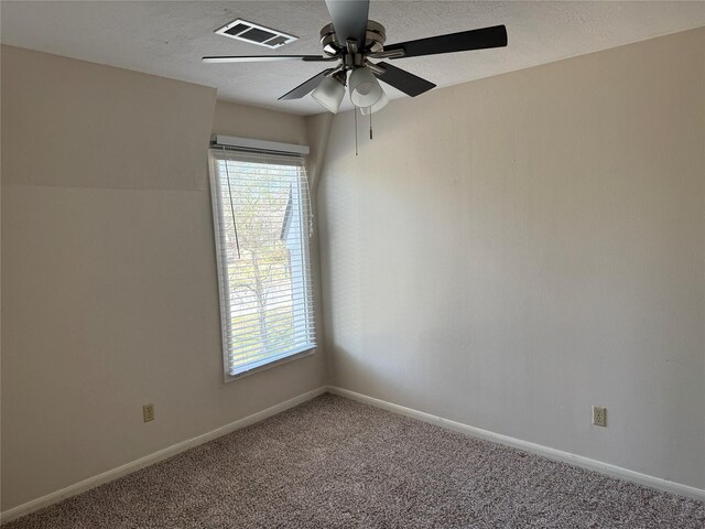 carpeted empty room featuring ceiling fan and a textured ceiling