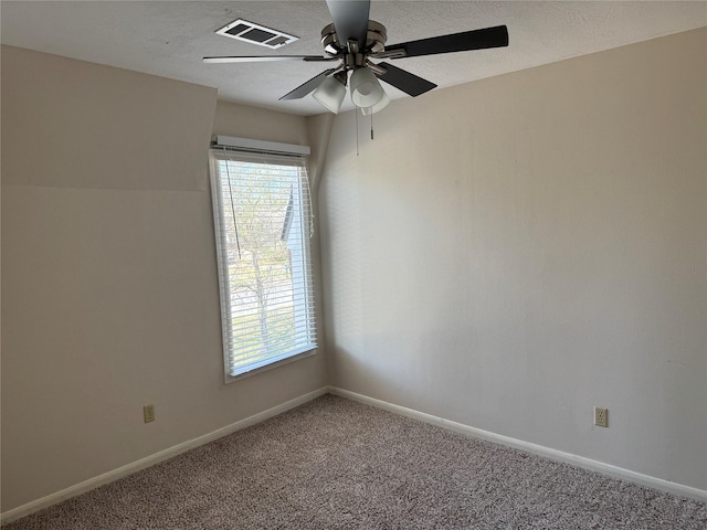 spare room featuring ceiling fan, carpet flooring, and a textured ceiling