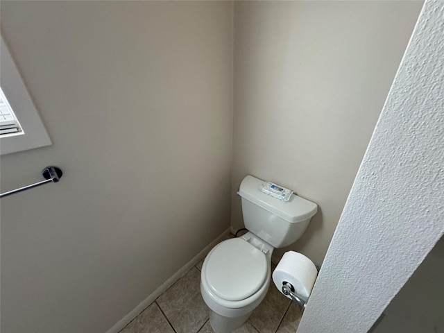 bathroom with toilet and tile patterned flooring