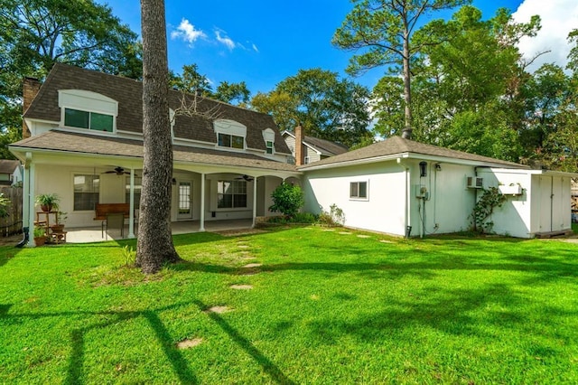 back of house featuring ceiling fan, a yard, a wall mounted AC, and a patio area