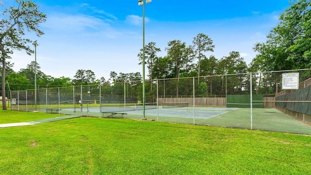 view of sport court with a lawn