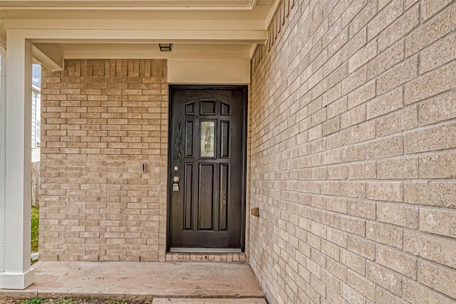 doorway to property featuring brick siding