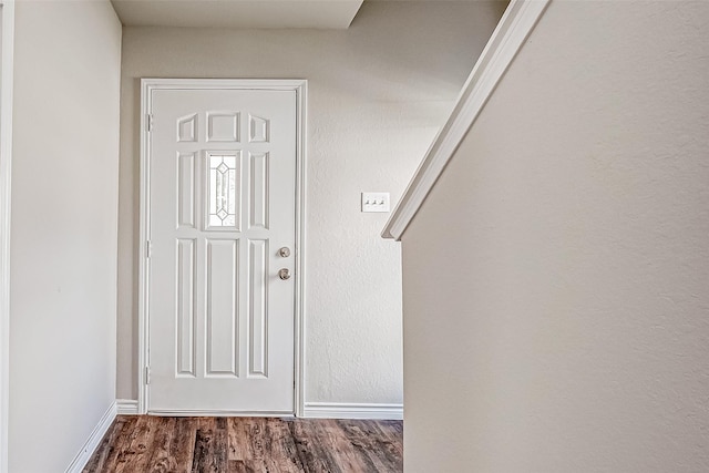 foyer entrance with dark wood finished floors and baseboards