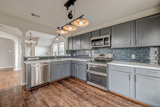 kitchen with pendant lighting, light countertops, visible vents, gray cabinetry, and appliances with stainless steel finishes