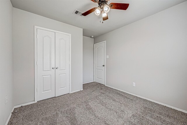 unfurnished bedroom featuring ceiling fan, visible vents, baseboards, a closet, and carpet