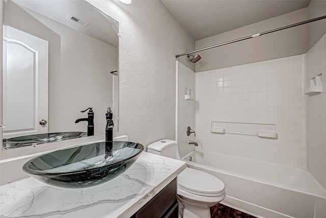 bathroom featuring shower / washtub combination, visible vents, a textured wall, toilet, and vanity