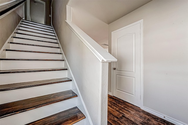 stairway with baseboards and wood finished floors