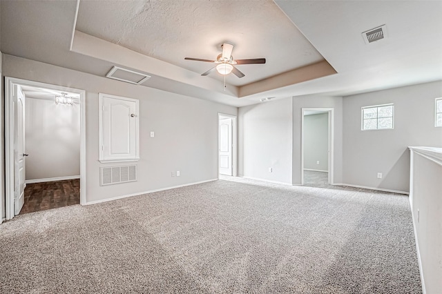 interior space featuring visible vents, a raised ceiling, and carpet flooring