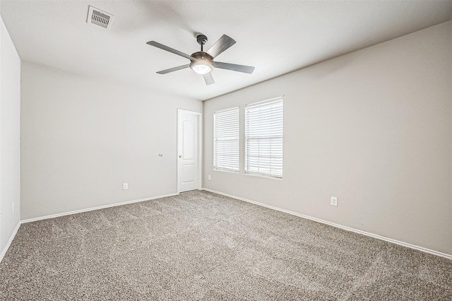 empty room with baseboards, carpet floors, visible vents, and a ceiling fan