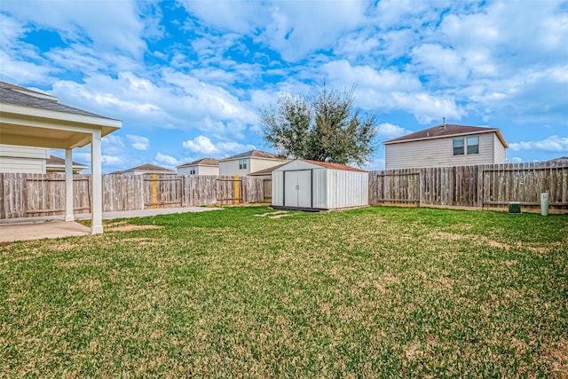 view of yard featuring a storage shed, a fenced backyard, and an outdoor structure