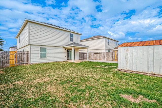 back of property with a shed, a patio, a lawn, and an outdoor structure