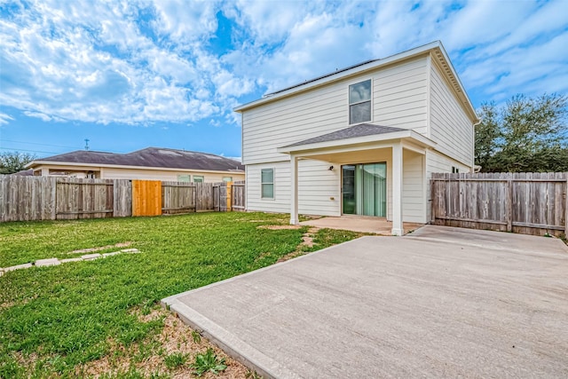 rear view of property with a yard, a fenced backyard, and a patio