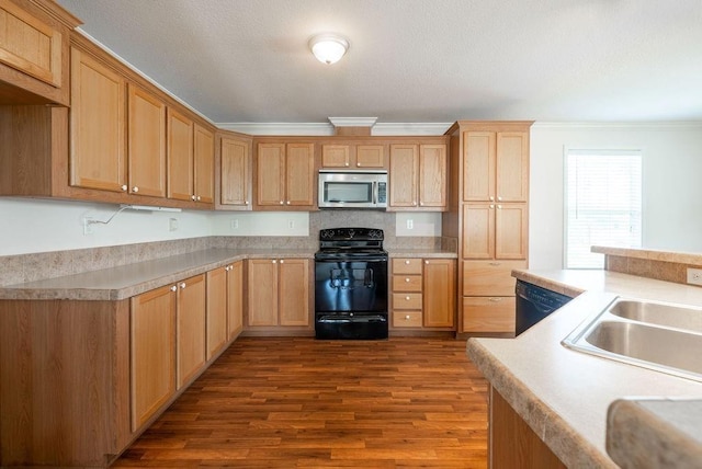 kitchen featuring crown molding, dark wood-type flooring, sink, and black appliances