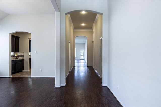 hallway with lofted ceiling, crown molding, and dark hardwood / wood-style floors