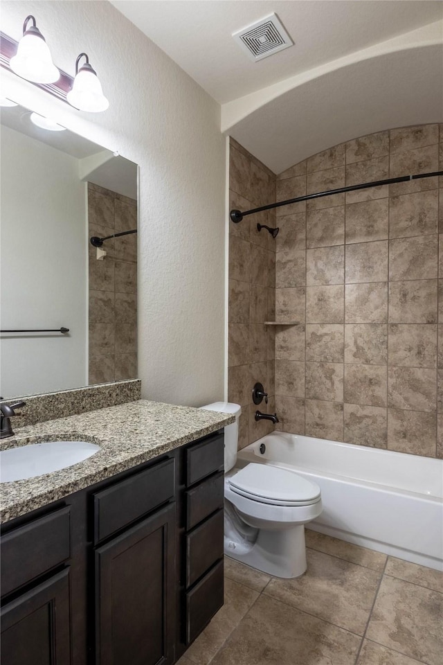 full bathroom featuring vanity, vaulted ceiling, toilet, and tiled shower / bath