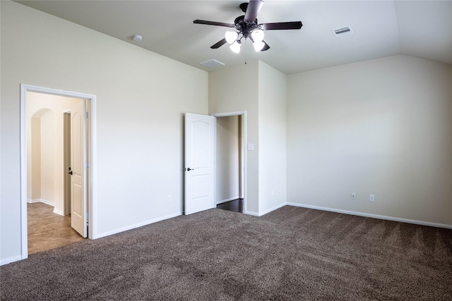 unfurnished bedroom featuring ceiling fan, lofted ceiling, and dark colored carpet