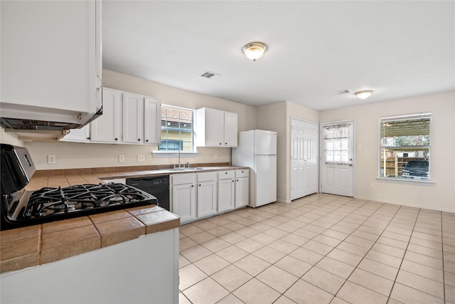 kitchen featuring white cabinetry, light tile patterned floors, white refrigerator, dishwasher, and stove