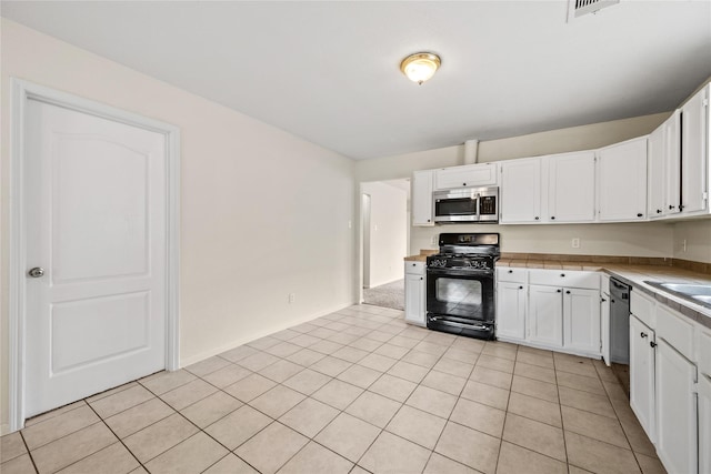 kitchen with white cabinetry, light tile patterned floors, and black appliances