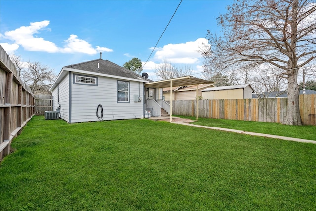 rear view of property featuring central air condition unit and a lawn