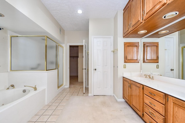 bathroom with independent shower and bath, vanity, tile patterned floors, and a textured ceiling