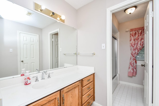 bathroom with vanity, tile patterned flooring, and combined bath / shower with glass door