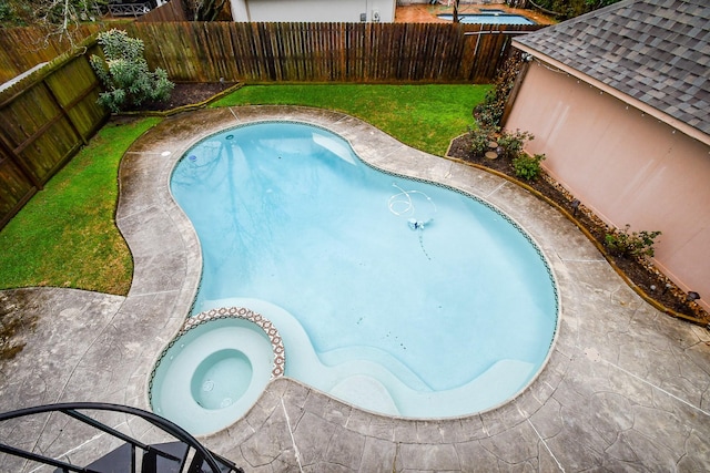 view of swimming pool with a lawn and an in ground hot tub