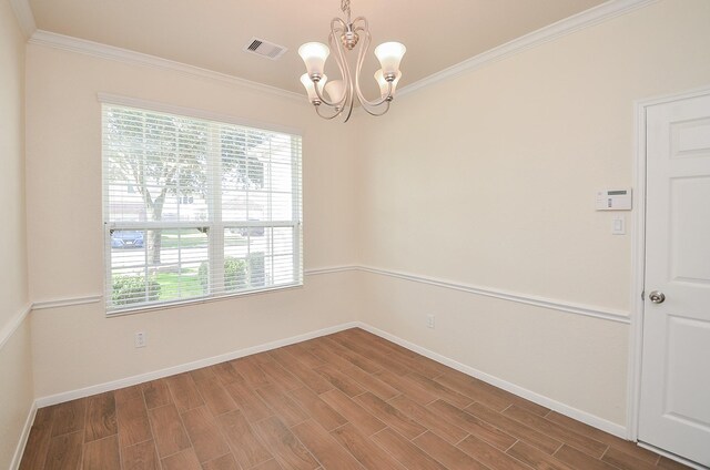 empty room with crown molding and an inviting chandelier