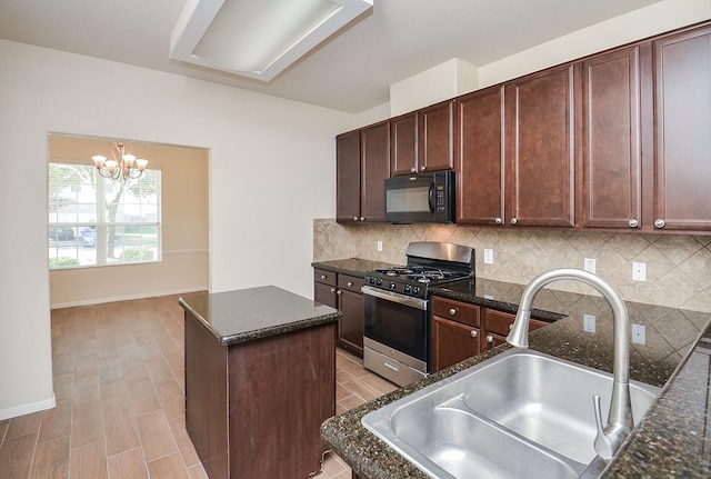 kitchen with a kitchen island, sink, dark stone countertops, decorative backsplash, and gas range