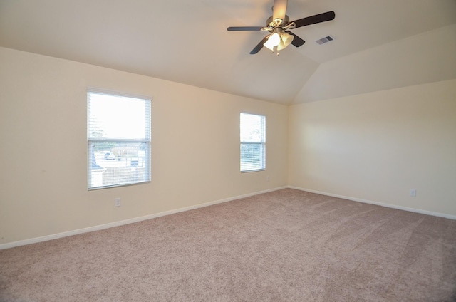 empty room with lofted ceiling, carpet floors, plenty of natural light, and ceiling fan