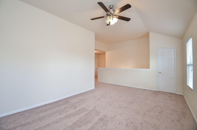 spare room with lofted ceiling, light colored carpet, and ceiling fan