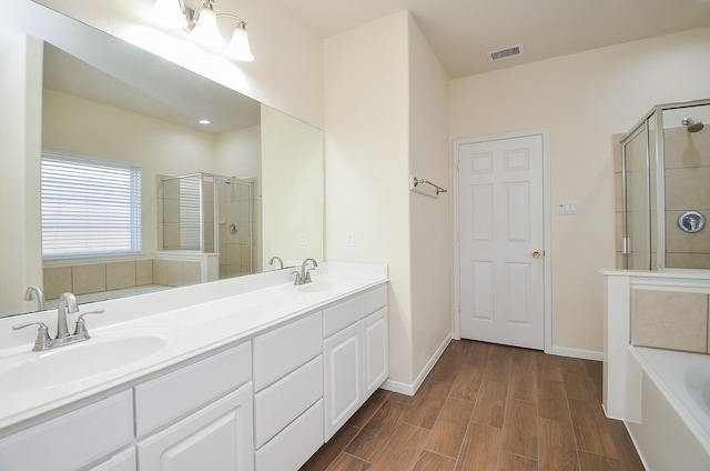 bathroom with vanity and shower with separate bathtub