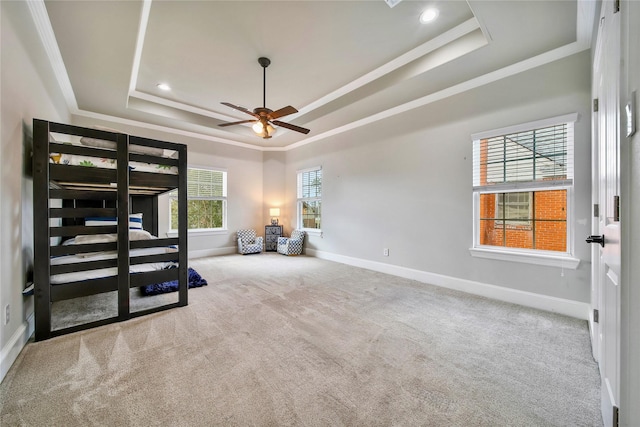 carpeted bedroom featuring ornamental molding and a tray ceiling