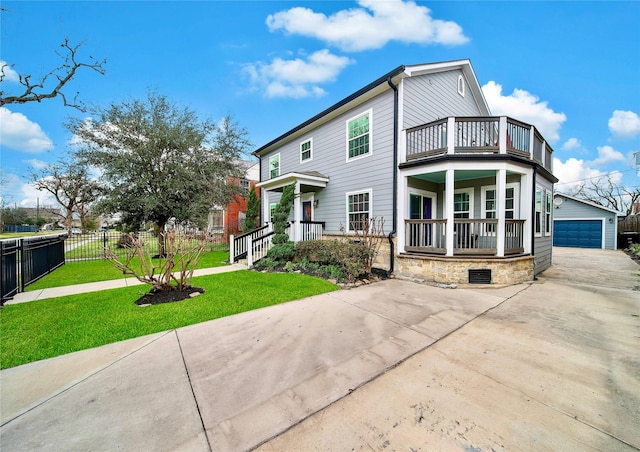 view of front of property with a porch, a balcony, an outbuilding, a garage, and a front lawn