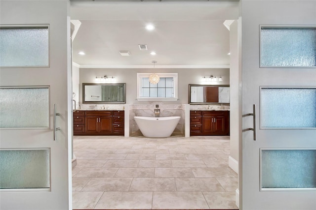 bathroom featuring vanity, a tub to relax in, crown molding, and tile patterned floors