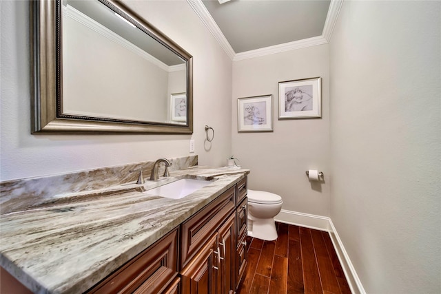 bathroom featuring vanity, hardwood / wood-style floors, crown molding, and toilet