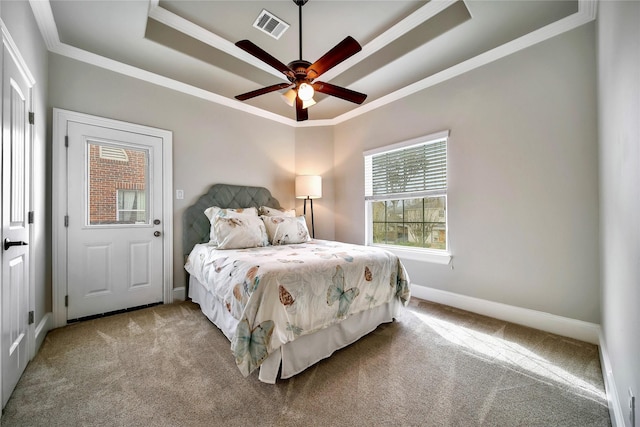 carpeted bedroom featuring crown molding, ceiling fan, and a raised ceiling