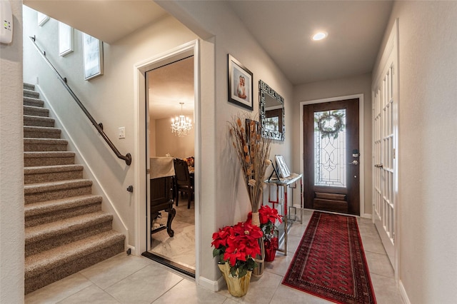 tiled entrance foyer featuring an inviting chandelier