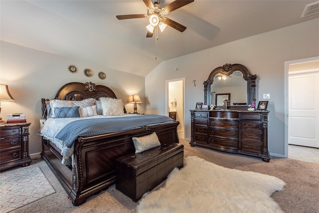 bedroom with light carpet, connected bathroom, vaulted ceiling, and ceiling fan