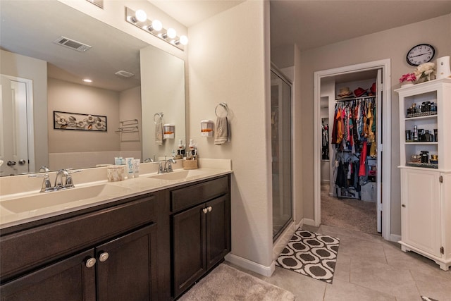 bathroom with walk in shower, vanity, and tile patterned flooring