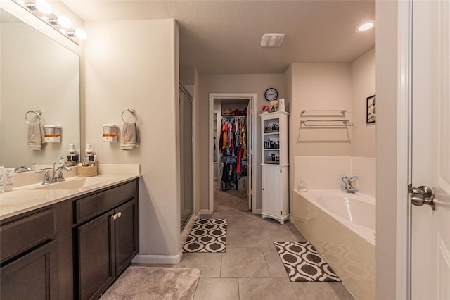 bathroom featuring independent shower and bath, vanity, and tile patterned floors