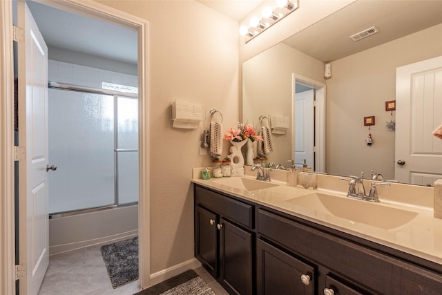 bathroom featuring tile patterned flooring, vanity, and shower / bath combination with glass door