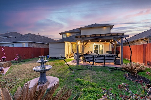 back house at dusk with an outdoor living space, a patio area, and a lawn