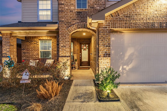 exterior entry at dusk featuring a garage