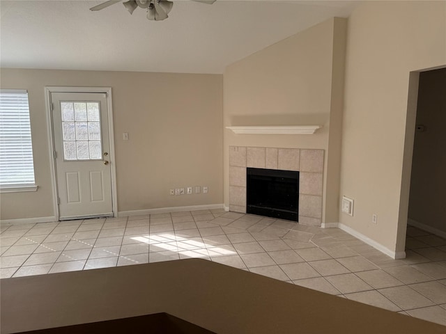 unfurnished living room featuring a fireplace, ceiling fan, and light tile patterned flooring