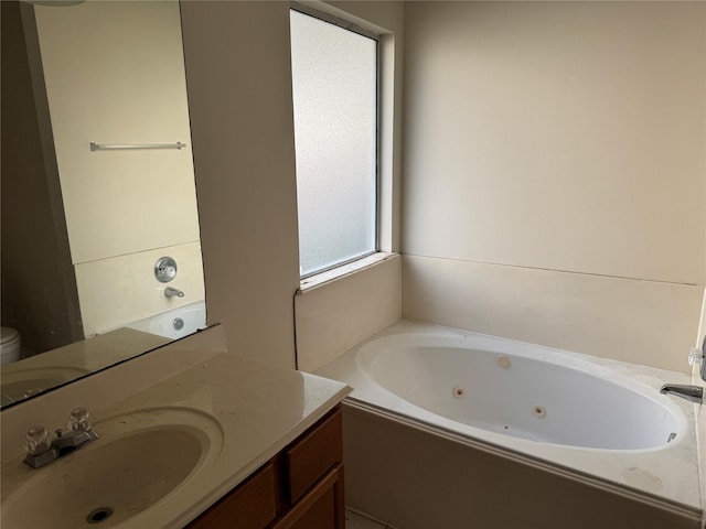 bathroom with vanity, a washtub, and toilet